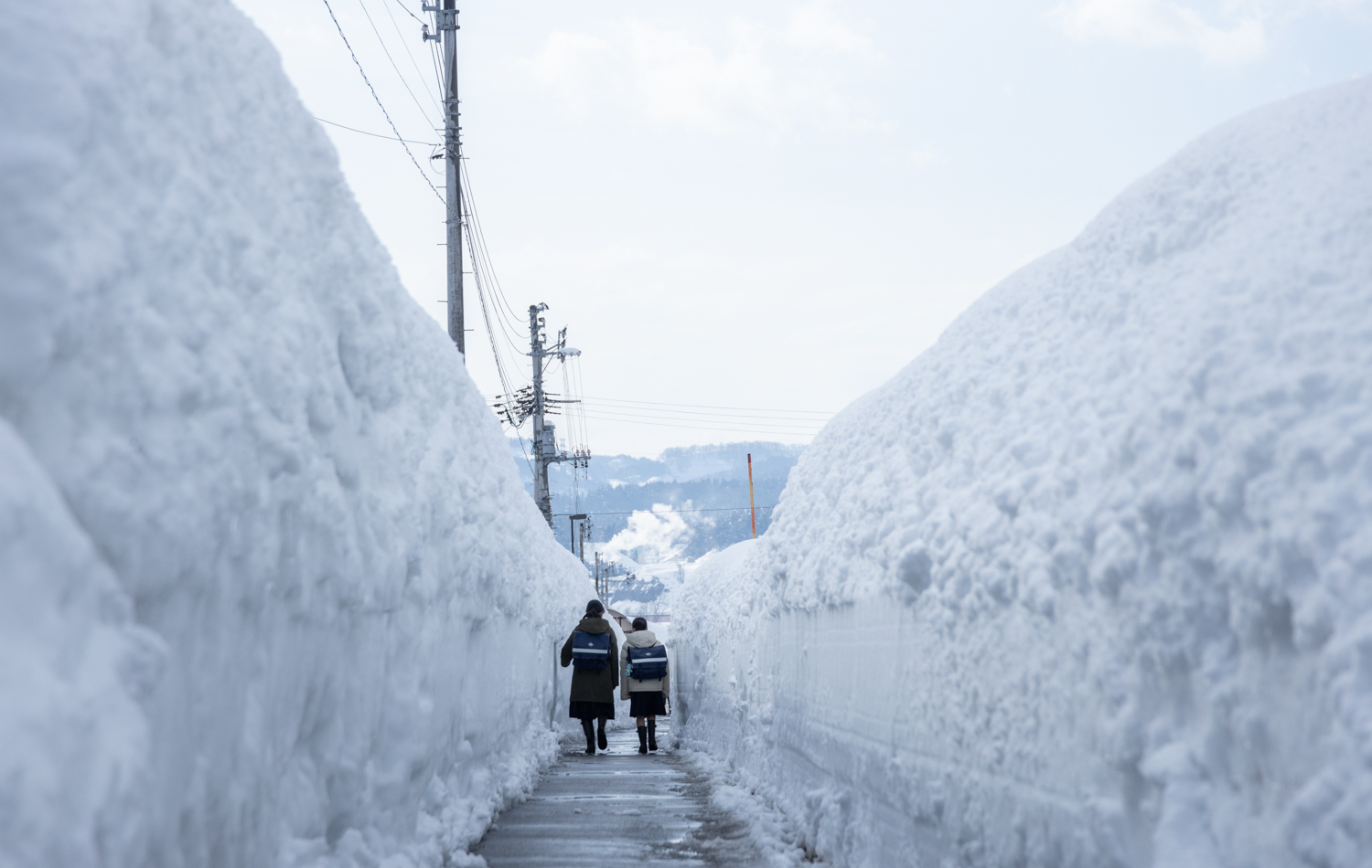 2mを超えることもある雪壁のなかの通学風景